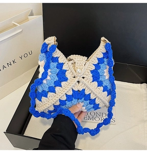 Detailed close-up of handmade crochet sunflower shoulder bag with pearl clasp and knit texture