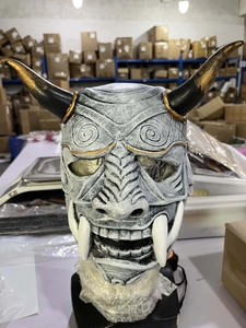 Detailed view of a grey resin Hannya demon mask with black and gold horns for cosplay