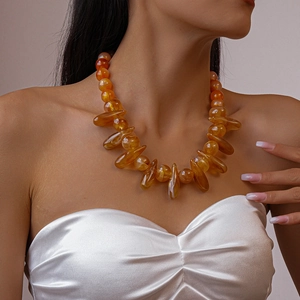 Detail shot of bohemian amber beaded necklace with irregular resin beads on neck