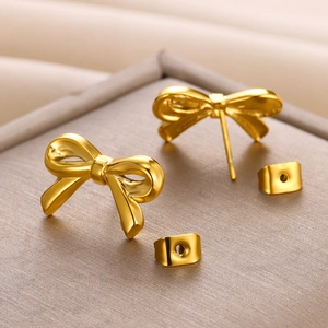 Macro shot of elegant 18K gold-plated bow stud earrings in a premium jewelry gift box