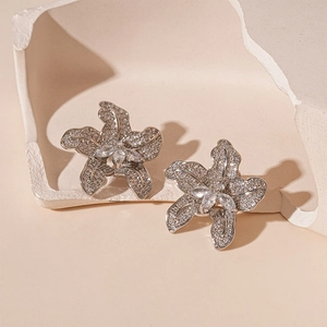 Elegant silver flower stud earrings with shimmering cubic zirconia on minimalist stone base