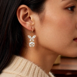 Gros plan de boucles d'oreilles papillon en zircon portées avec élégance par un modèle