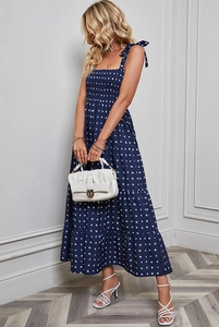 Detail of navy blue floral maxi dress featuring tie straps and ruffled tiered hemline