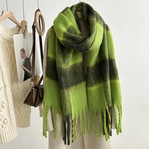 Detail of green and black checkered mohair scarf with long tassels for winter outfits