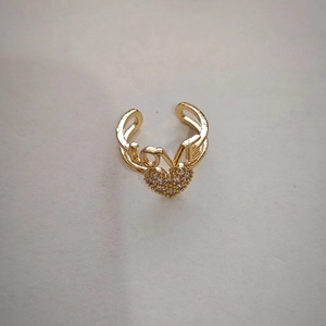 Macro detail of gold-plated LOVE ring featuring a sparkling heart with pave crystals