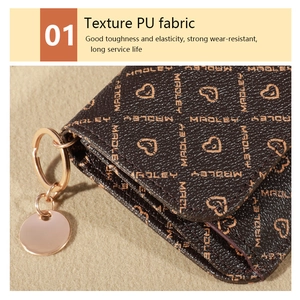 Macro detail of textured PU leather wallet with MADLEY print and rose gold keyring