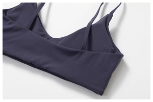 Close-up of fine double shoulder straps and flat seam stitching on a purple sports bra
