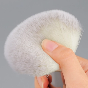 Large fluffy powder brush with soft synthetic bristles for a flawless makeup finish