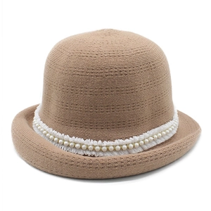 Close-up of knit cloche hat with white lace trim and elegant pearl embellishments