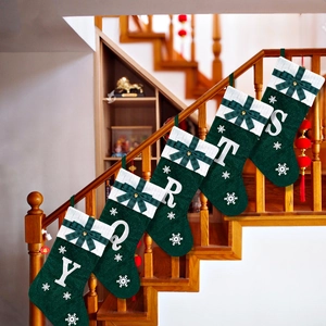 Detail of five green embroidered Christmas stockings with plush tops on a staircase