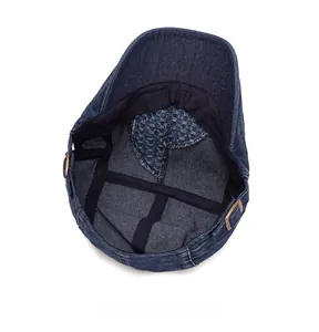 Detail of vintage denim flat cap featuring adjustable metal buckles and mesh lining