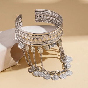 Macro detail of silver coin tassel arm bracelet with hollow geometric patterns
