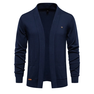 Detail of navy knit cardigan with ribbed cuffs, pockets and small metal emblem