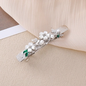 Dettaglio del fermaglio per capelli in argento con fiori di conchiglia, perle e foglie