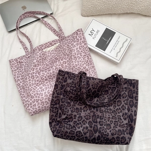 Flat lay of large leopard print tote bags in lavender and coffee brown suede textures
