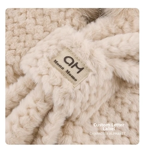 Close-up of soft plush fox ear hat fabric with an artistic AM and Mona Momo woven label