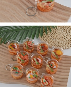 Detailed macro view of multiple mini transparent cup noodle keychains with colorful food props