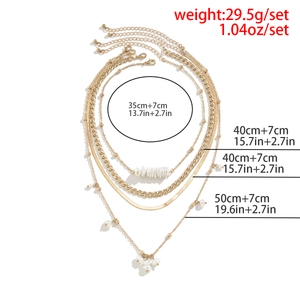 Four-layer gold layered necklace set with faux pearl tassels and flat snake chain detail