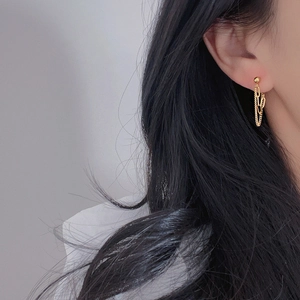 Detail of 18k gold plated double chain drop earrings worn by a model in a minimalist style