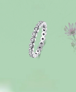 Macro detail of silver eternity ring featuring a bezel setting with round cubic zirconia
