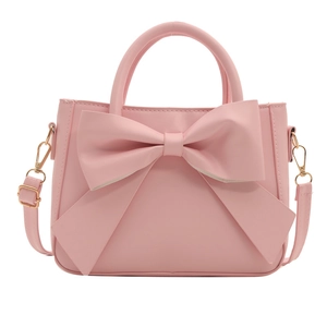 Chic pink bucket bag featuring a large bow decoration with top handle and shoulder strap