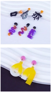 Detailed view of colorful geometric and irregular resin earrings on wavy display