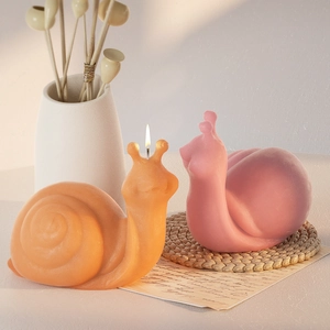 Artistic snail aromatherapy candles in orange and pink featuring a soft matte finish