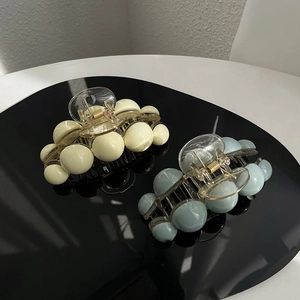 Pinces à cheveux élégantes en perles acryliques jaunes et bleues sur un support noir