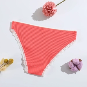Detail of coral orange ribbed cotton panties with delicate white lace trim and soft texture