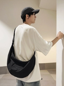 Sac bandoulière homme en nylon noir style dumpling, vue latérale portée par un mannequin