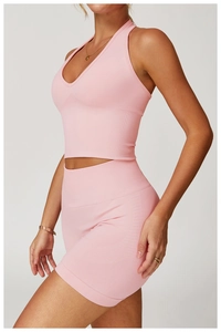 Detail der Textur von nahtlosem, rosa Neckholder-Sport-BH und High-Waist-Shorts im Set