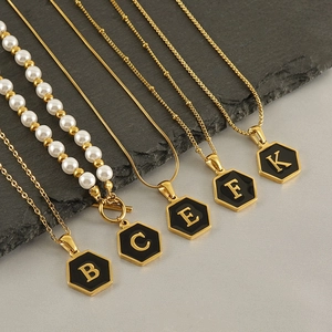 Golden stainless steel layered necklaces with hexagonal black enamel initial pendants