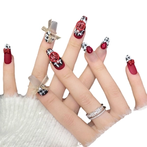 Handmade red New Year press-on nails with houndstooth patterns and golden bows
