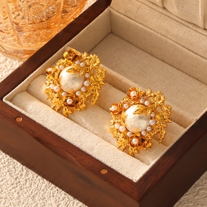 Baroque pearl flower earrings in gold vintage palace style on a wooden jewelry box