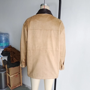 Detail of tan faux suede long coat featuring brown leather collar and cross-stitch back seams