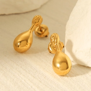 18k gold plated stainless steel teardrop earrings on white textured stone background