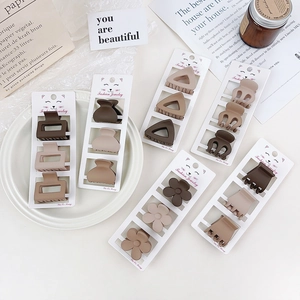 Detailed view of 3-piece matte brown hair clip set in flower and geometric shapes