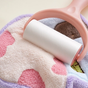 Detail showing pink lint roller removing dust from plush fabric surface clearly