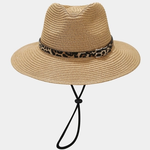 Detail of hand-woven straw hat featuring leopard print band and silver metal buckle