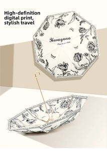 Detail of vintage French floral umbrella with elegant gold handle and digital printing