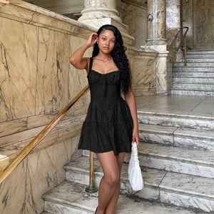 Robe noire élégante à bretelles et volants avec taille cintrée sur un mannequin
