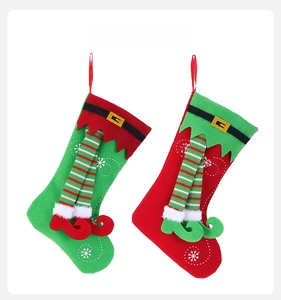 Detail of felt Christmas stockings with elf legs, snowflakes, and belts for decor
