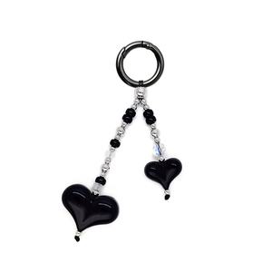 Detail of beaded keychain with two black heart pendants and black spring ring buckle