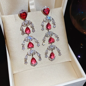 Detail of luxury teardrop red gemstone earrings with silver cascading crystal tassels