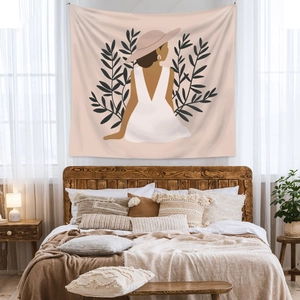 Detail of bohemian tapestry featuring a minimalist female illustration as bedroom wall decor