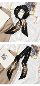 Detail of black silk scarf with golden celestial sun and moon patterns for hair styling