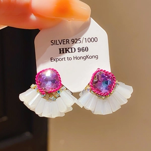 Détail de boucles d'oreilles en argent 925 avec pierres rouges et perles blanches en éventail