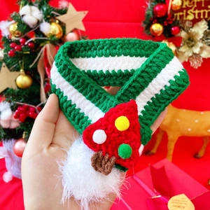 Detail of hand-knitted Christmas tree pet scarf with forest green wool and red mushrooms
