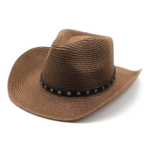 Detail of brown straw cowboy hat featuring black leather band and silver metal rivets