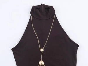 Detail of halter neck dress featuring gold chain and spherical metallic accents